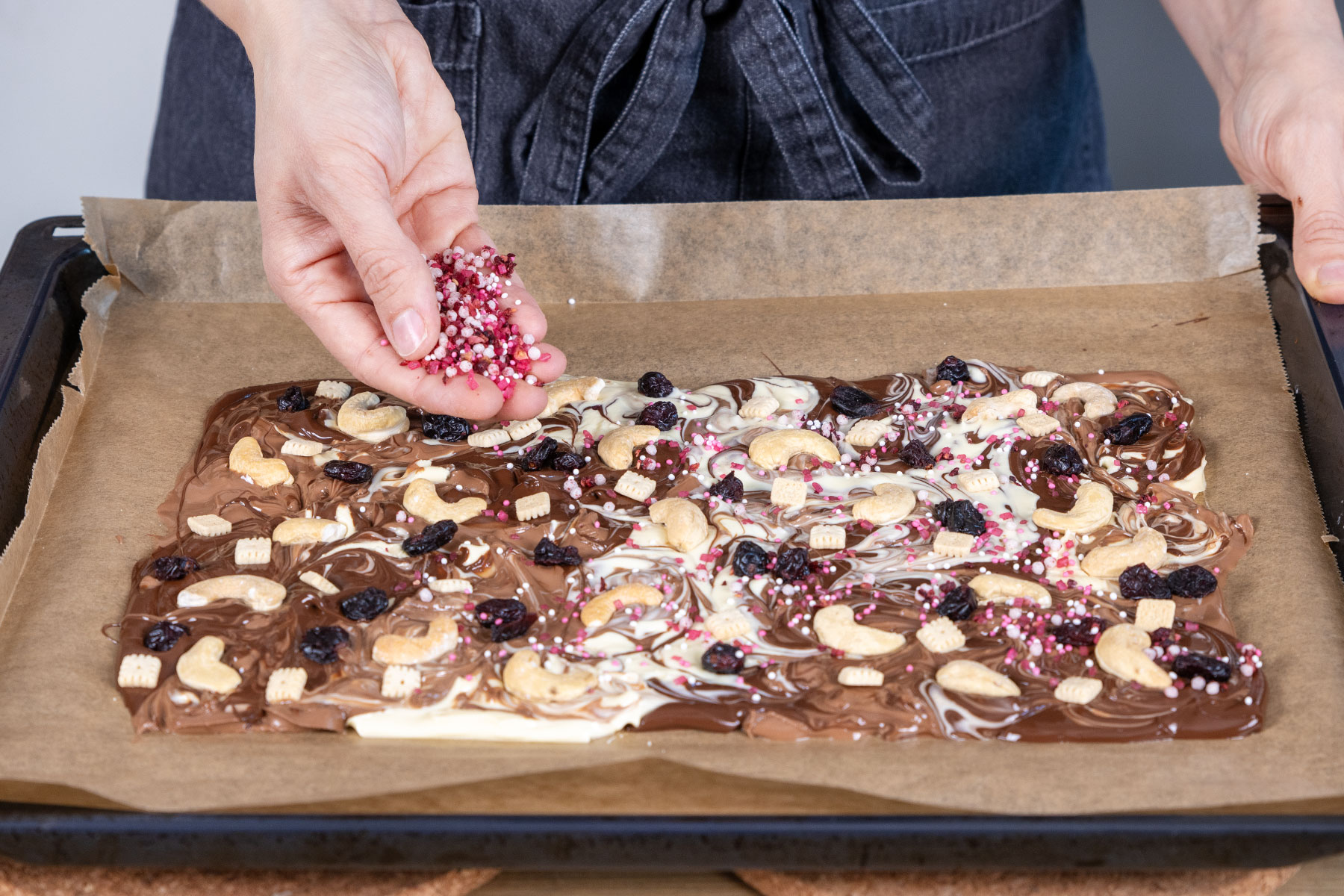 Bruchschokolade aus dem Backofen mit Toppings bestreuen