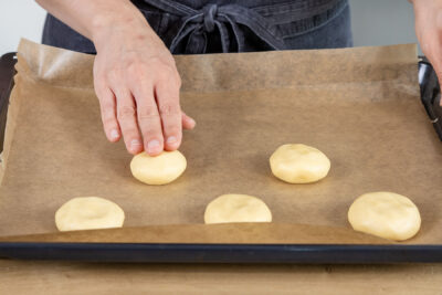 Teigkugeln auf dem Backblech andrücken