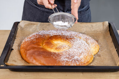 Ensaimada nach Original-Rezept aus Mallorca mit Puderzucker bestäuben