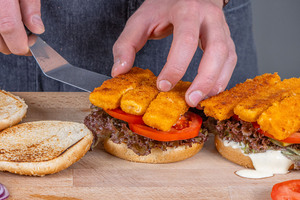 Fischstäbchen auf den Burger geben
