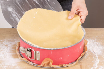 Decke auf den gefüllten Apfelkuchen legen
