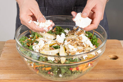 geröstete Walnüsse und Feta über den Grünkohlsalat bröseln