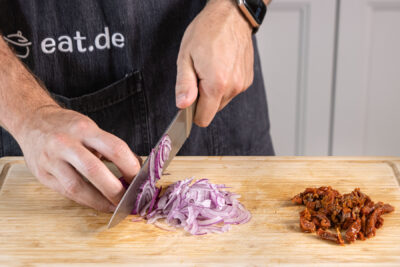 Zwiebel und getrocknete Tomaten fein schneiden
