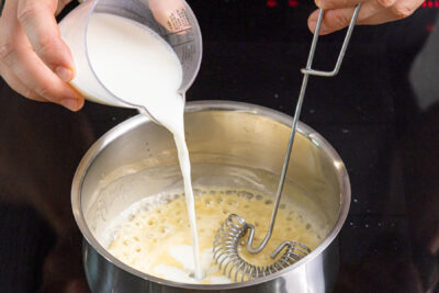 Milch zur Mehlschwitze gießen