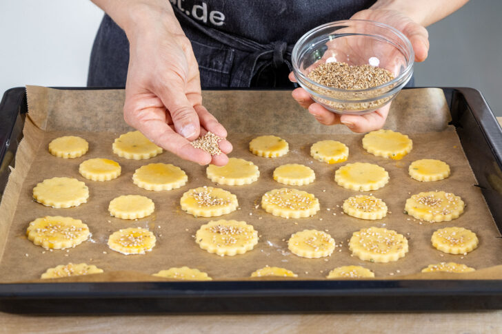 Sesam auf die Käseplätzchen streuen