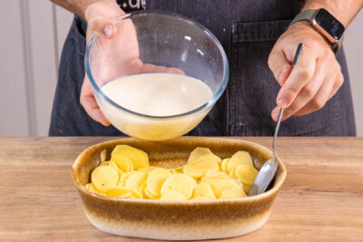 Soße über die Kartoffeln gießen
