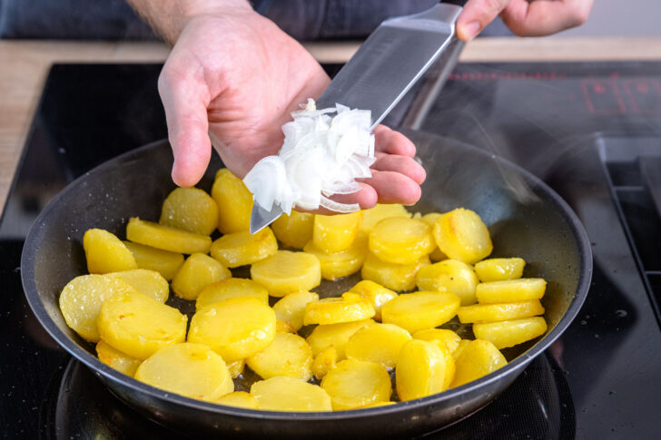 Zwiebeln zu Kartoffeln geben