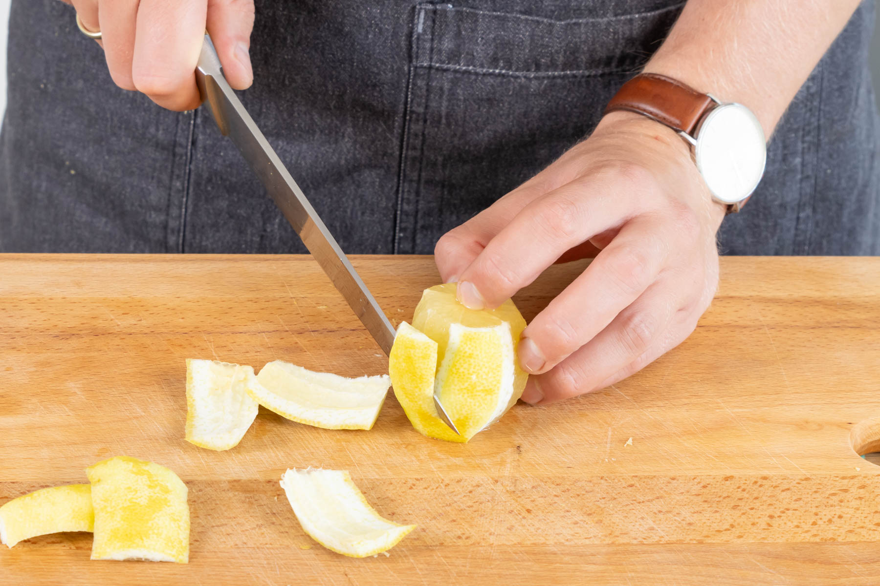 Zitrone schälen und in Scheiben schneiden