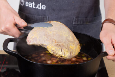 Den Braten in die Soße geben.