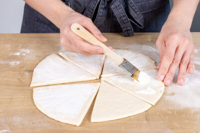 Teig mit Frischkäse einstreichen