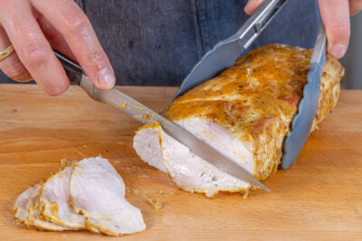 Schweinelachsbraten aus dem Ofen in Scheiben schneiden
