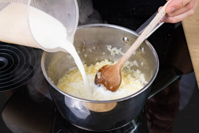 Milch zu den angebratenen Zwiebeln geben
