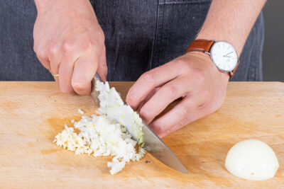 Zwiebeln und Knoblauch in feine Würfel schneiden