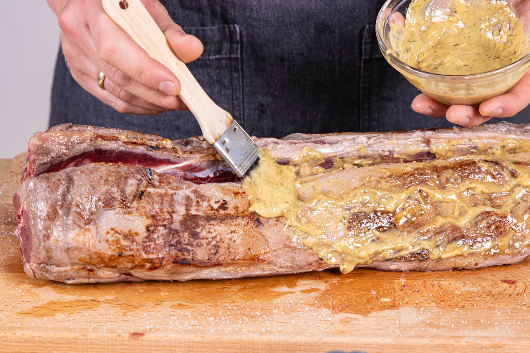 Wildschweinrücken mit Marinade einpinseln