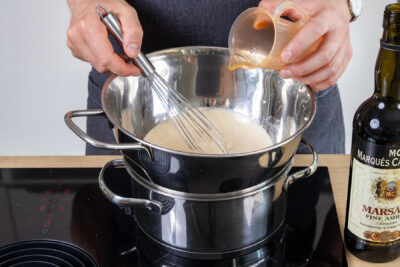Marsala zu der Creme über dem Wasserbad gießen