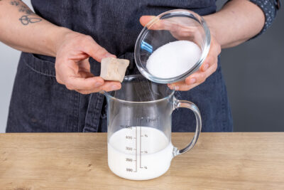 Hefe und Zucker zur lauwarmen Milch geben