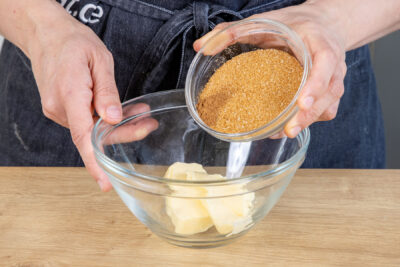 Zucker und Zimt zur Butter geben