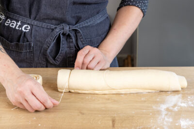 Zimtschnecken von der Teigrolle abtrennen