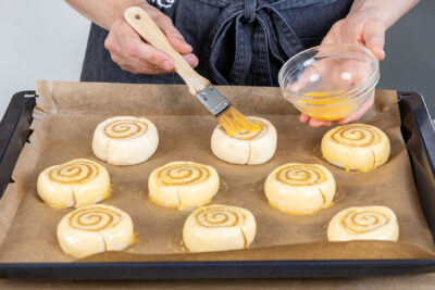 Zimtschnecken mit Eigelb-Mischung bestreichen
