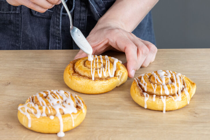 Zimtschnecken mit Zuckerguss überziehen