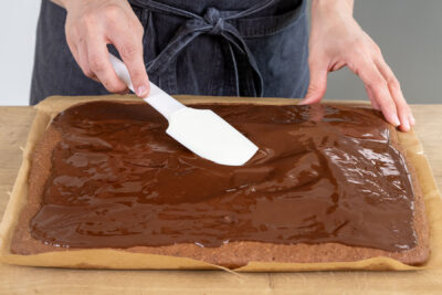 Schokoglasur auf dem Gewürzkuchen verteilen