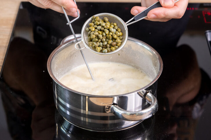 Kapern in die Sauce geben
