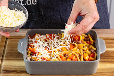 Makkaroniauflauf mit Hackfleisch und Gemüse mit Käse bestreuen und backen