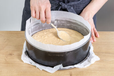 Rührteig für den Mandelkuchen in die Springform geben