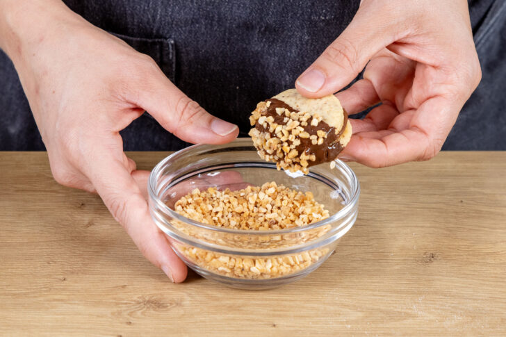 Nuss-Nougat-Plätzchen in Krokant wälzen