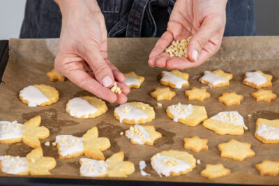 Omas Butterplätzchen mit Mandeln bestreuen
