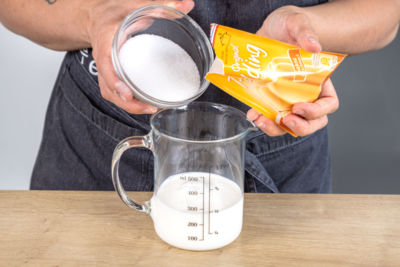 Puddingpulver mit Zucker in Milch auflösen