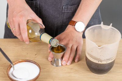 Rum und Zucker zum Kaffee geben