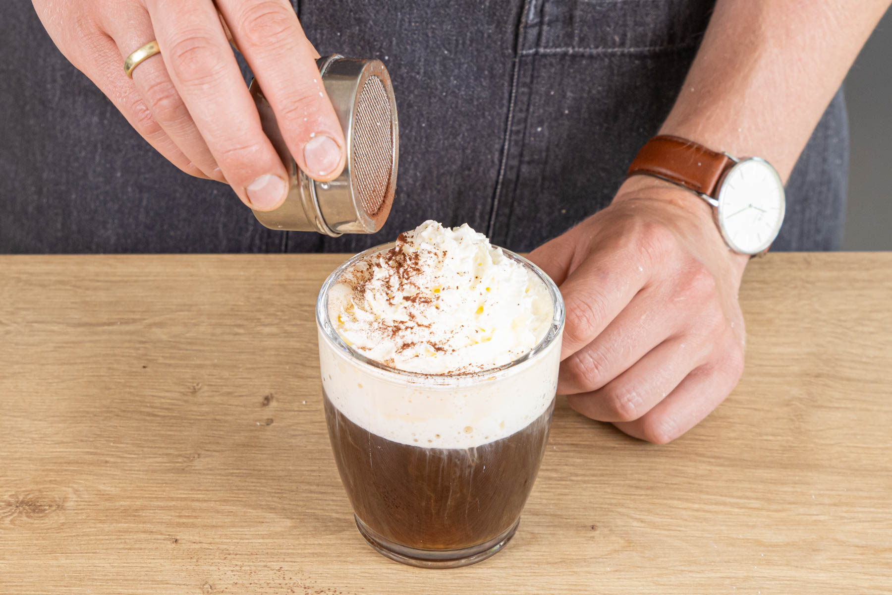 Pharisäer Kaffee mit Sahne und Kakaopulver garnieren