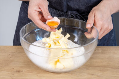 Eigelb in die Schüssel zum Mehl und Butter geben