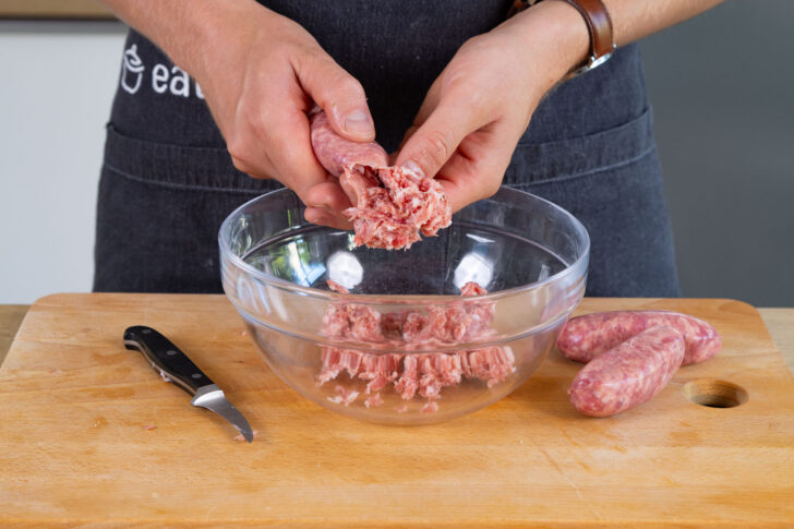 Salsiccia aus Haut drücken.