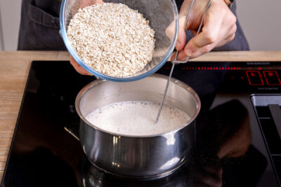 Haferflocken zur Milch geben