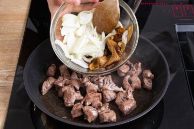 Ragout mit Zwiebeln und Pilzen anbraten