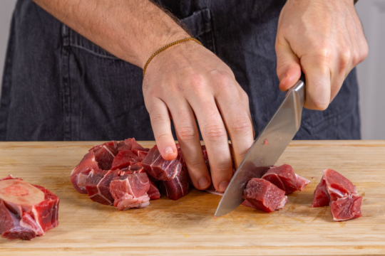 Suppenfleisch vom Rind in mundgerechte Stücke schneiden