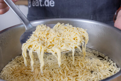 Spätzle aus dem Topf nehmen