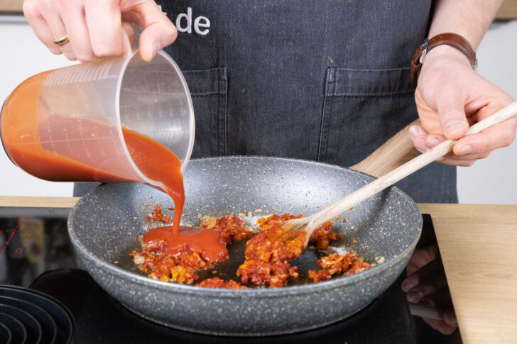 Passierte Tomaten dazu schütten.