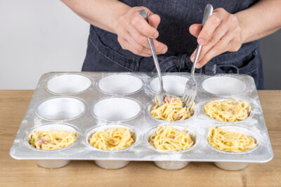 Spaghettinester in die Muffinform geben