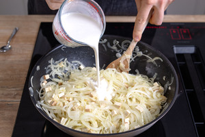 Vegane Sahne zu Zwiebeln geben