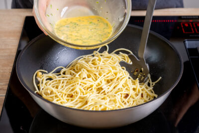Eimasse zu den Spaghetti geben