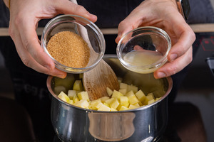 Zitronensaft und Zucker zu Äpfeln geben