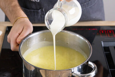 Sahne zur Brokkoli-Kartoffel-Suppe geben