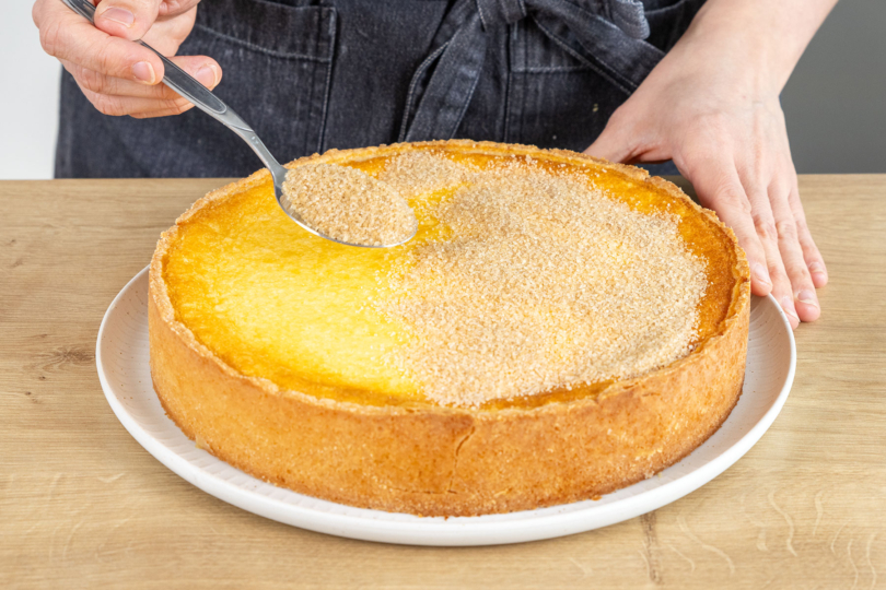 Zimt-Zucker auf dem Crème Brûlée-Kuchen verteilen