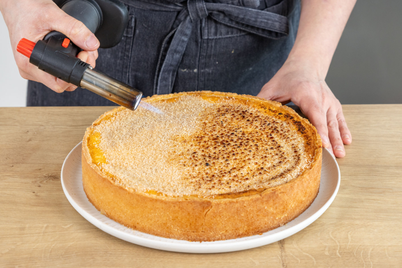 Zuckerschicht des Crème Brûlée-Kuchen flambieren