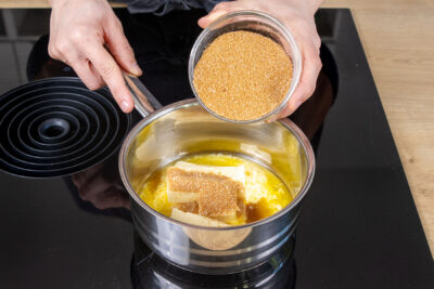 Zucker zur Butter in den Topf geben