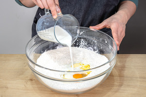 lauwarme Milch und Ei in Schüssel geben