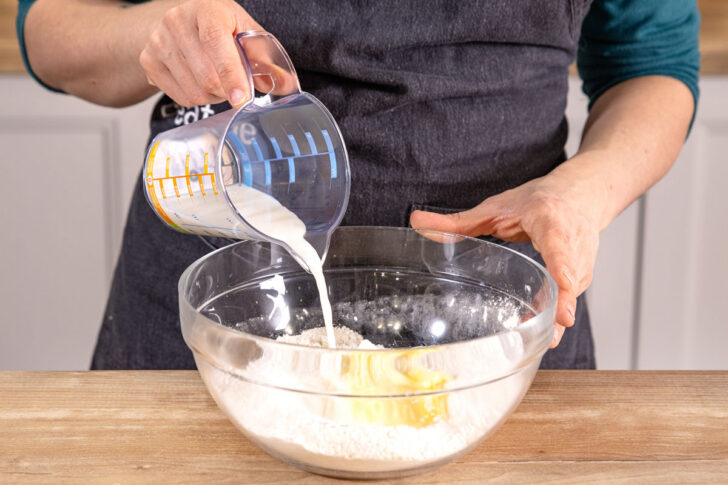 Butter, Joghurt und Milch zum Teig geben